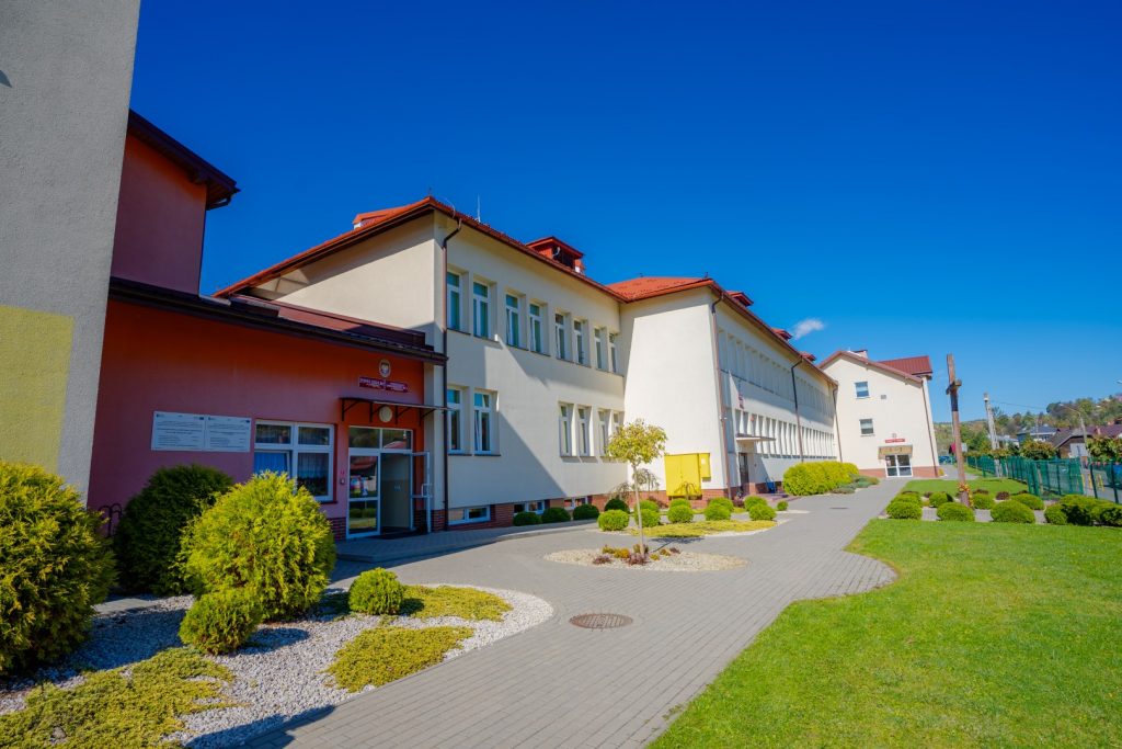 Duży budynek szkolny z czerwonym dachem