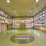 Sala sportowa z boiskiem do piłki ręcznaj. Na ścianach wiszą kosze do koszykówki