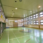 Sala sportowa z boiskiem do piłki ręcznaj. Na jednej ze ścian drabinki i kosz