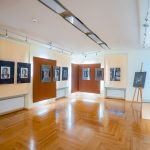 Sala wystawowa z kolekcją czarno-białych zdjęć w antyramach