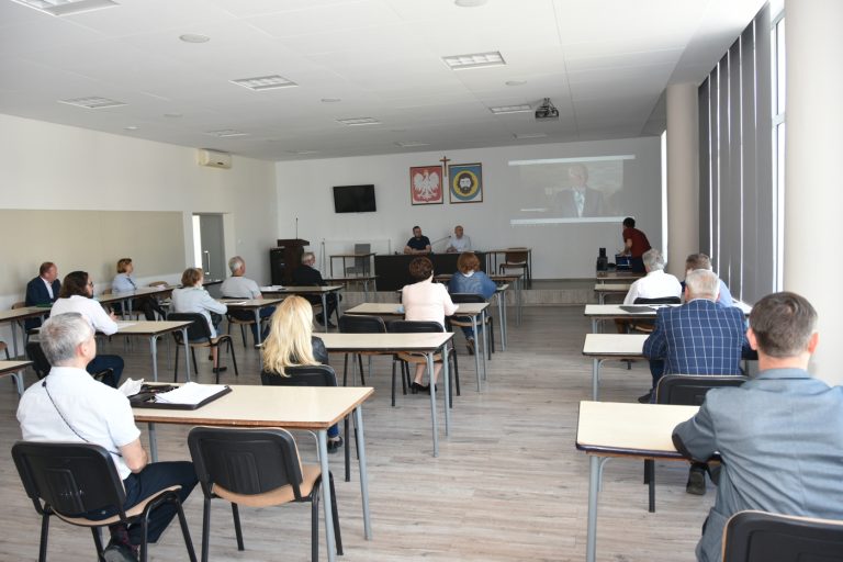 Grupa osób ogląda wideokonferencję.