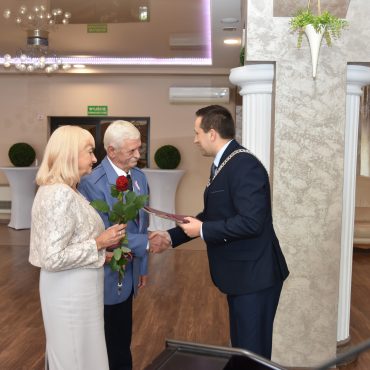 Burmistrz Brzozowa Szymon Stapiński wręcza medale i listy gratulacyjne parze z pięćdziesięcio letnim stażem małżeńskim, gratulując i uściskując dłonie