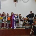 Grupa dzieci na scenie śpiewa kolędy.