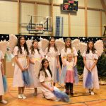 Grupa dziewcząt przebranych w strój aniołów. Wszyscy znajdują się na sali gimnastycznej.